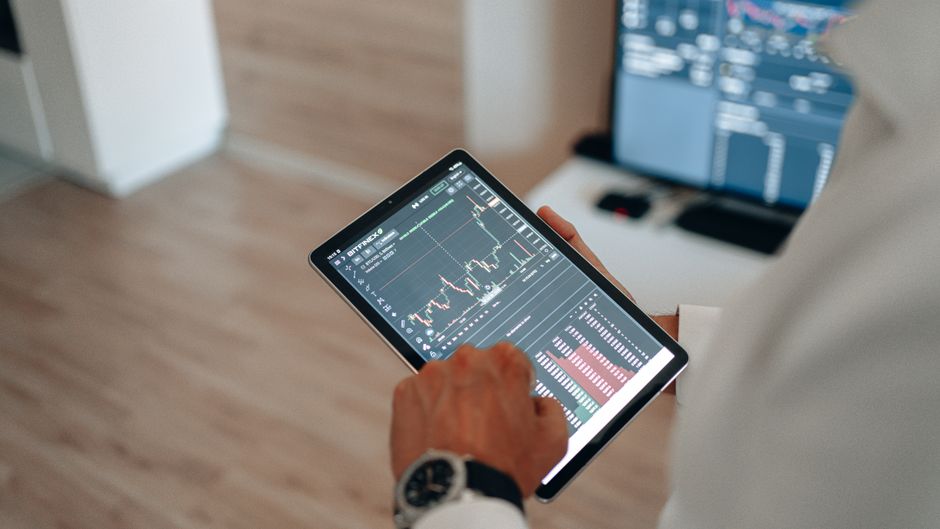 Blizina ruku koje koriste tablet za online trgovanje i analizu tržišta.